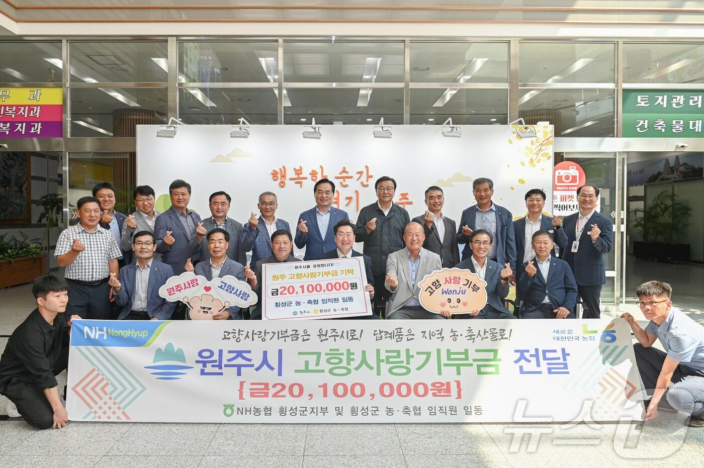 본문 이미지 - NH농협 횡성군지부와 횡성군 지역 농·축협 관계자들이 9일 오전 11시 강원 원주시청 중회의실에서 원주시 고향사랑기부금으로 2010만 원을 전달하고 시청 로비에서 기념 사진을 촬영하고 있다. (원주시 제공) 2024.9.9/뉴스1