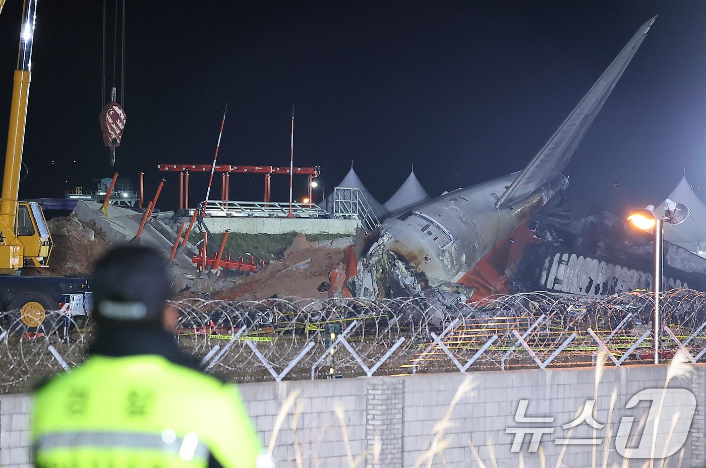 본문 이미지 - 1일 전남 무안국제공항 제주항공 여객기 참사 현장에 사고 여객기와 충돌로 부서진 방위각 시설(로컬라이저), 대형크레인 등이 보이고 있다. 2025.1.1/뉴스1 ⓒ News1 김진환 기자