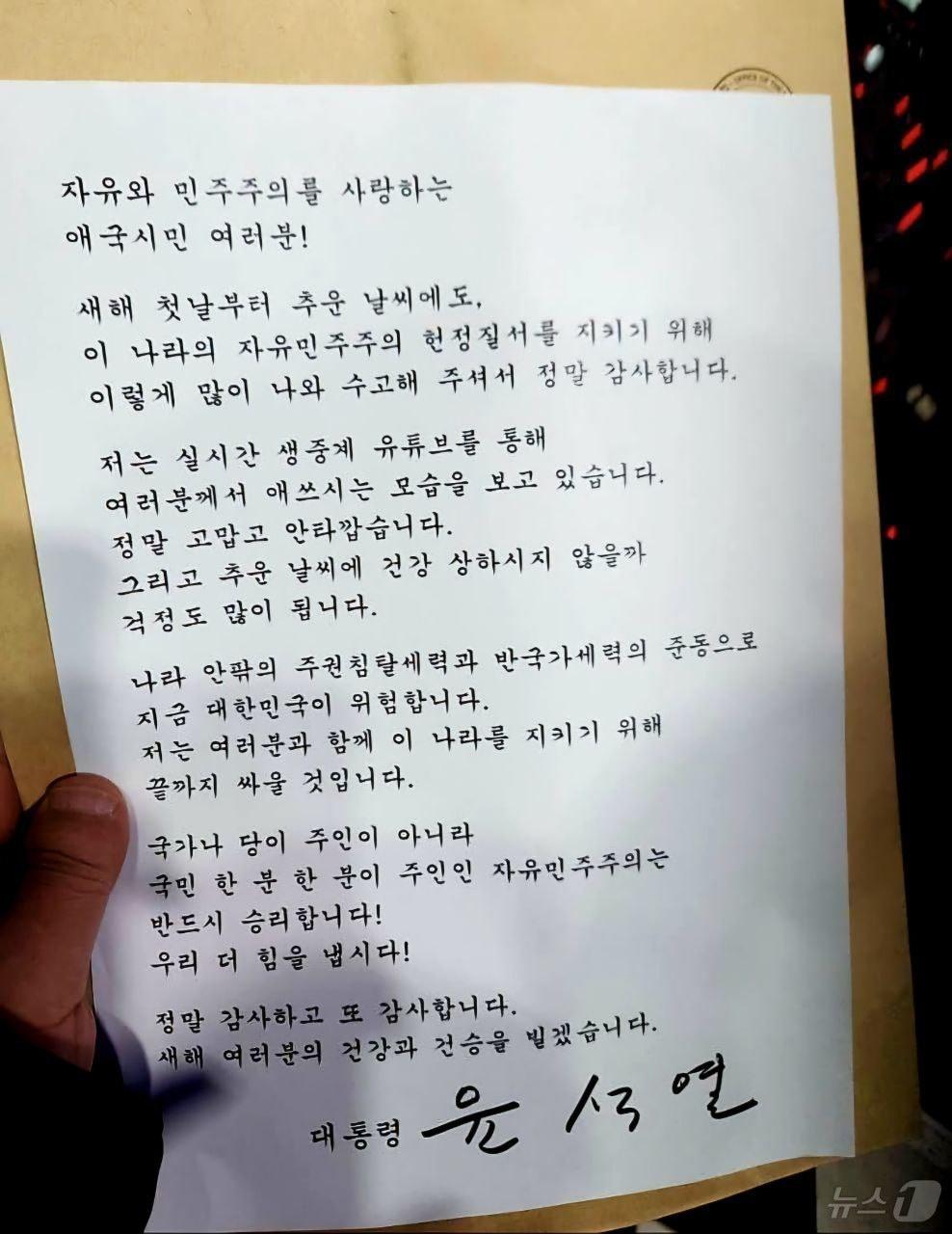 본문 이미지 - 윤석열 대통령은 1일 서울 용산구 한남동 대통령 관저 앞에 모인 지지자들을 향해 &#34;여러분과 함께 이 나라를 지키기 위해 끝까지 싸울 것＂이라고 밝혔다. 윤 대통령 변호인단 구성을 돕는 석동현 변호사에 따르면, 윤 대통령은 이날 오후 7시 30분쯤 관계자를 통해 자필 서명이 담긴 메시지를 집회 현장에 전달했다. 윤 대통령은 ＂나라 안팎의 주권침탈세력과 반국가세력의 준동으로 지금 대한민국이 위험하다＂며 이같이 말했다. &#40;석동현 변호사 제공&#41; 2025.1.1/뉴스1
