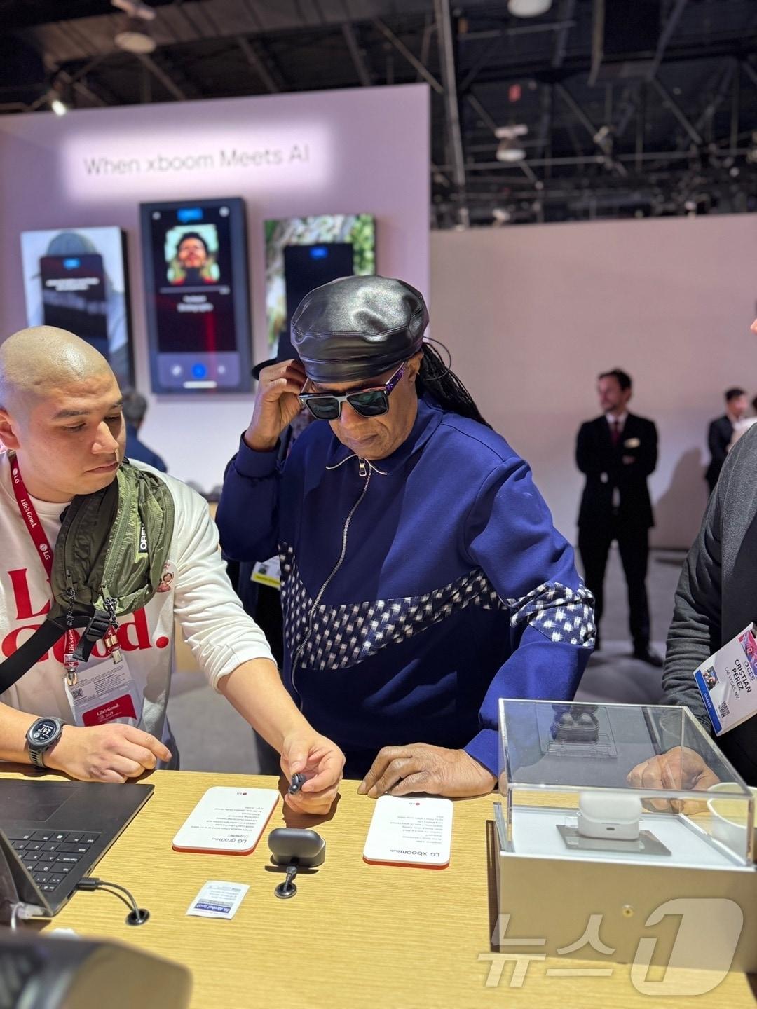 본문 이미지 - 미국의 싱어송라이터가 9일&#40;현지시각&#41; CES 2025 LG전자 부스를 방문해 무선 이어폰 &#39;엑스붐 버즈&#39;를 청음하고 있다&#40;독자 제공&#41;. ⓒ 뉴스1