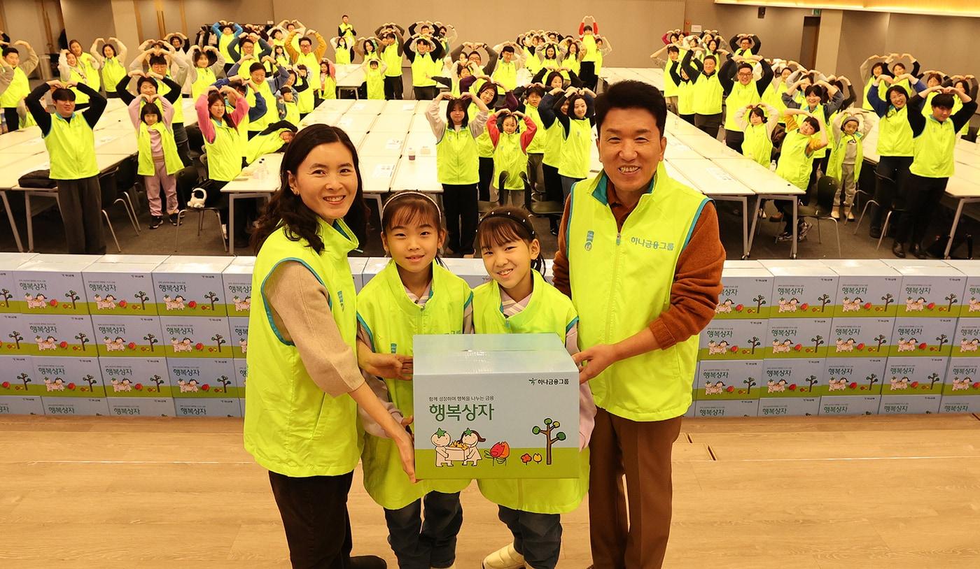 봉사활동에 참석한 함영주 회장(사진 오른쪽에서 첫번째)이 직원 가족과 함께 직접 빚은 떡세트 및 풍성한 명절 먹거리를 담은 행복상자를 들고 기념촬영을 하고 있다 (하나금융그룹 제공)