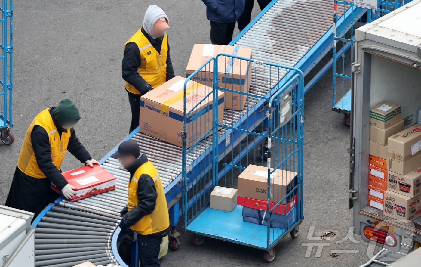본문 이미지 -  13일 서울의 한 택배 물류센터에서 택배 기사들이 분주히 배송 준비 작업을 하고 있다. 2025.1.13/뉴스1 ⓒ News1 이동해 기자