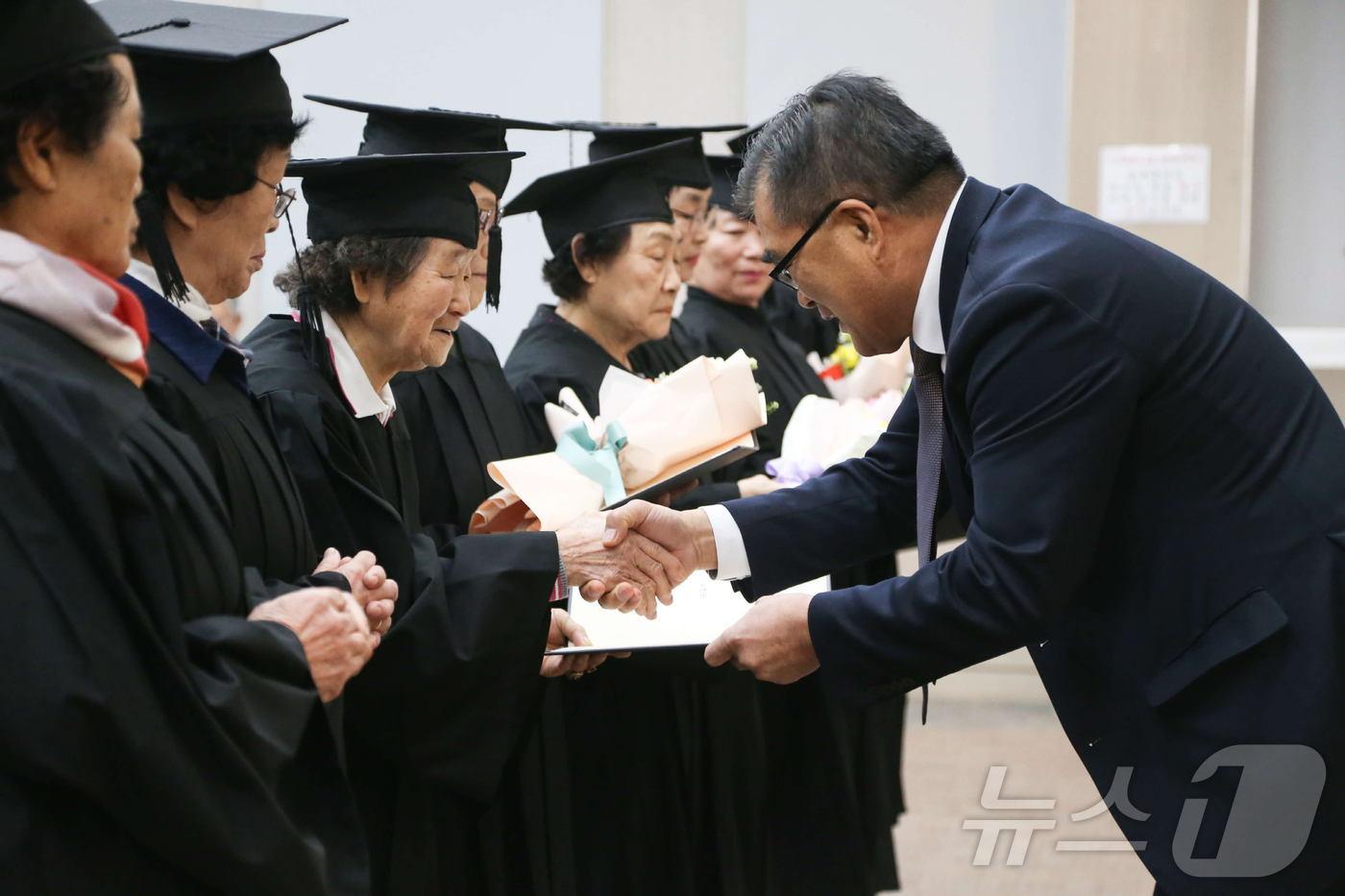 김기웅 서천군수(오른쪽)가 초·중 학력을 인정받은 문해교육 수료생들과 기념촬영을 하고 있다.(서천군 제공)/뉴스1