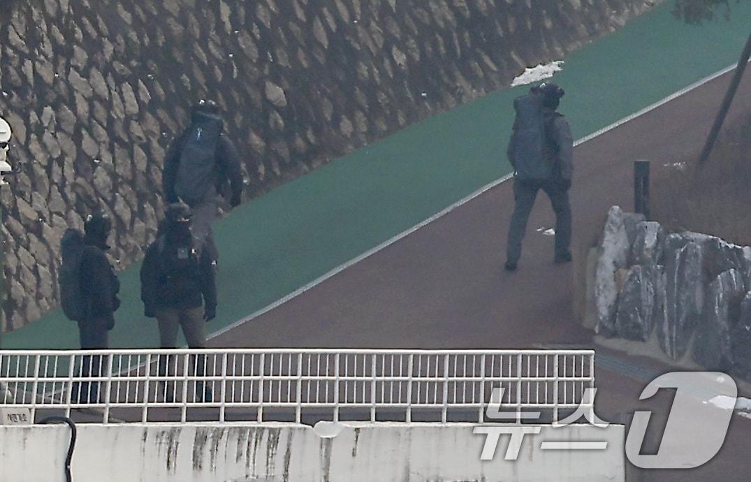 본문 이미지 - 13일 서울 용산구 한남동 대통령 관저에서 화기가 든 것으로 추정되는 배낭을 멘 대통령경호처 요원들이 오가고 있다. 2025.1.13/뉴스1 ⓒ News1 박정호 기자