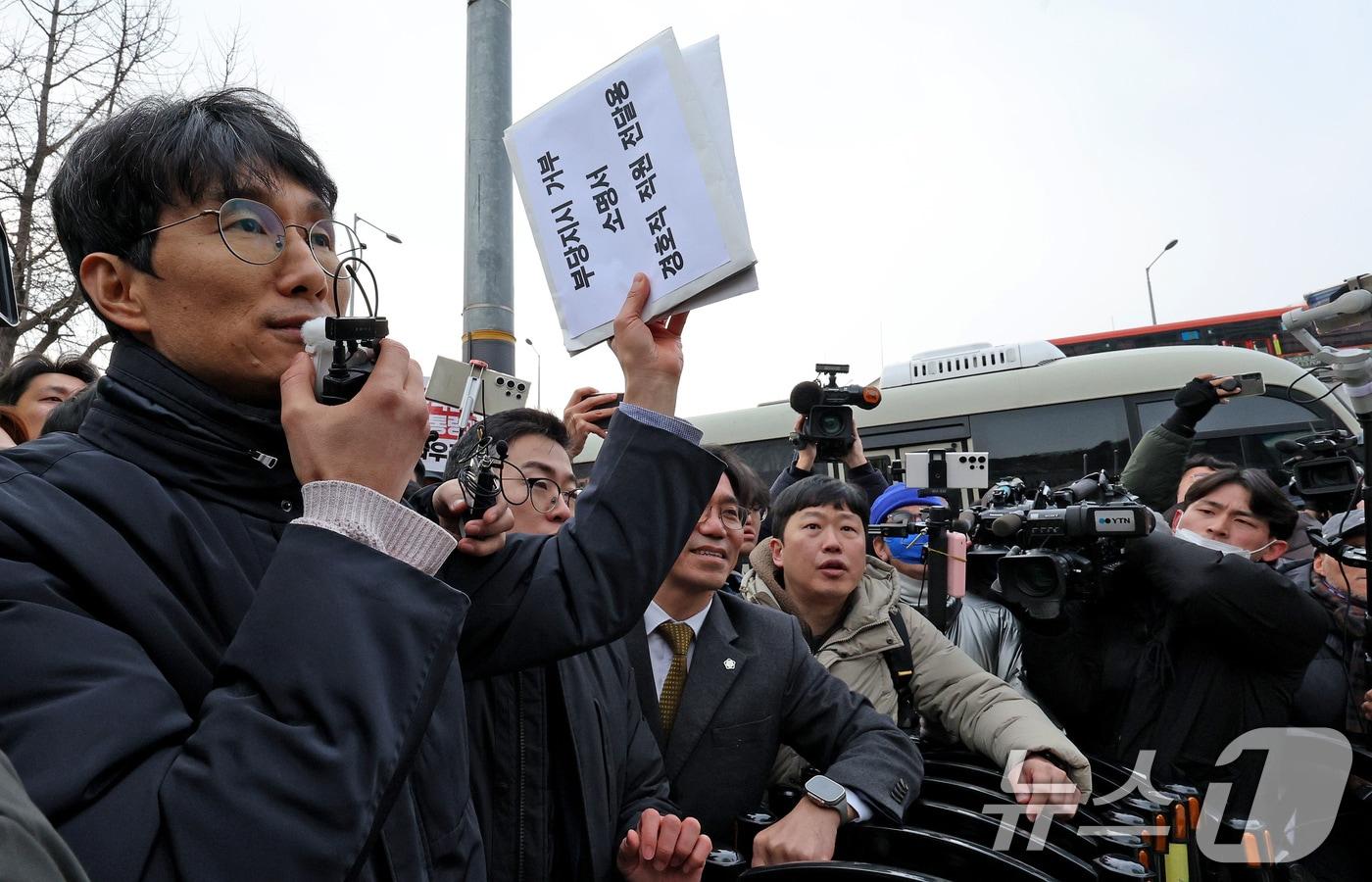 서울중앙지법 판사 출신 차성안 서울시립대 법학전문대학원 교수&#40;왼쪽&#41;와 윤석열체포변호사단이 지난 1월 13일 오후 서울 용산구 한남동 대통령 관저에서 경호처 직원들에게 전달할 &#39;부당지시 거부 소명서&#39;를 들어 보이고 있다. 변호인단은 &#34;수사당국의 윤 대통령 체포영장 집행을 물리적으로 막으라는 명령은 부당 지시에 해당해 법적인 복종의무가 없다＂며 경호처 직원들에게 지시 불이행을 촉구했다. 2025.1.13/뉴스1 ⓒ News1 장수영 기자