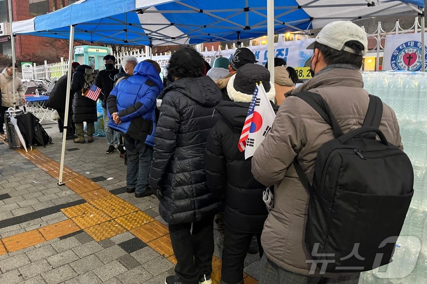 14일 오전 7시쯤 서울 용산구 한남동 윤석열 대통령 관저 인근에서 윤 대통령 지지자들이 아침을 먹기 위해 줄을 서고 있다. 2025.1.14/ 뉴스1