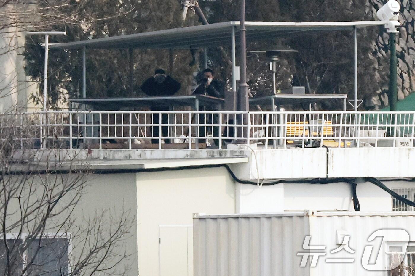 공수처와 경찰의 윤석열 대통령 2차 체포영장 집행 시도가 임박한 가운데 14일 서울 용산구 한남동 대통령 관저에서 망원경과 캠코더를 든 경호처 요원들이 바깥 동향을 살피고 있다. 2025.1.14/뉴스1 ⓒ News1 오대일 기자