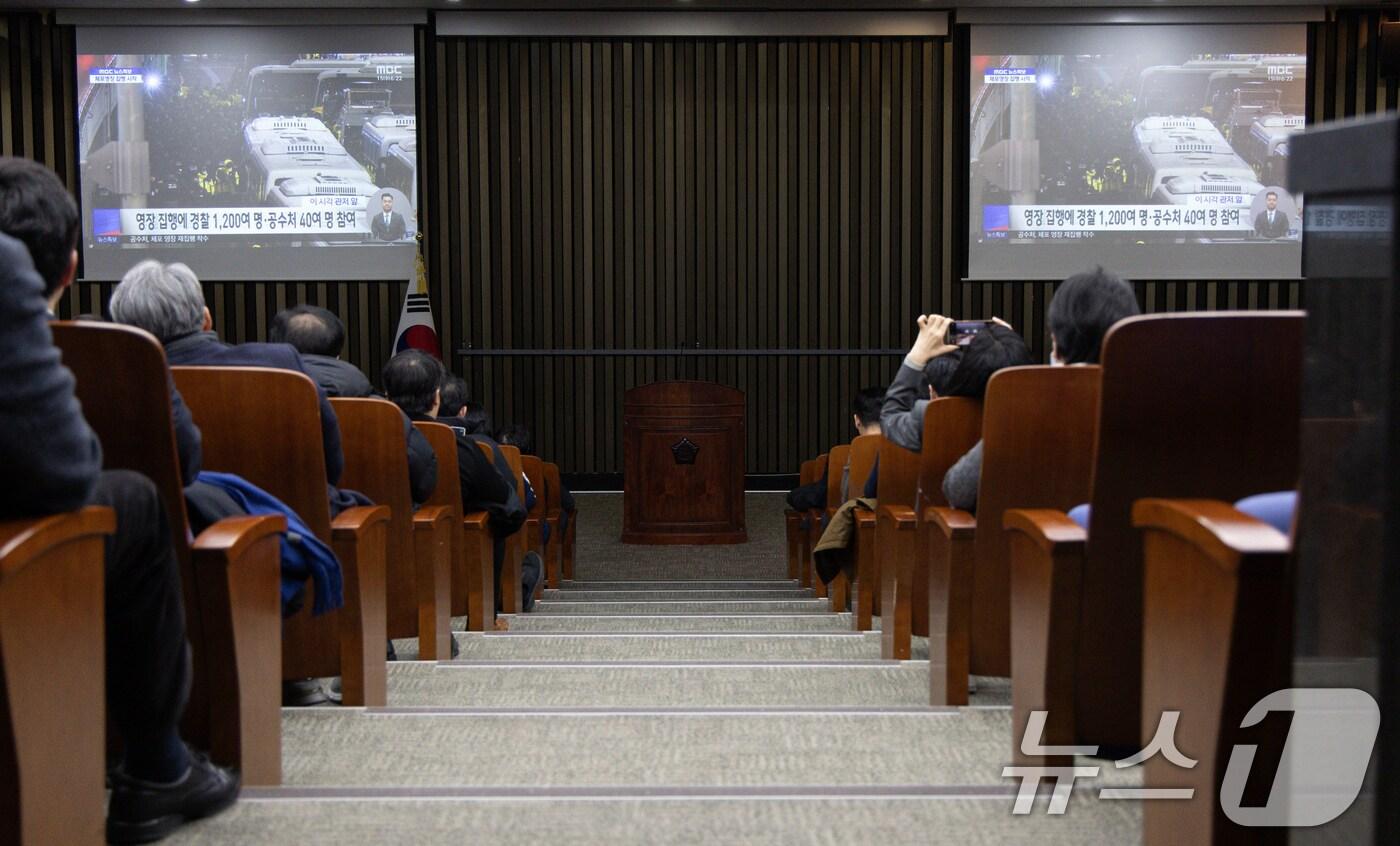 더불어민주당 의원들이 15일 서울 여의도 국회에서 열린 비상의총에서 공수처의 윤석열 대통령 체포영장 집행 뉴스 생중계를 살펴보고 있다. 2025.1.15/뉴스1 ⓒ News1 이재명 기자