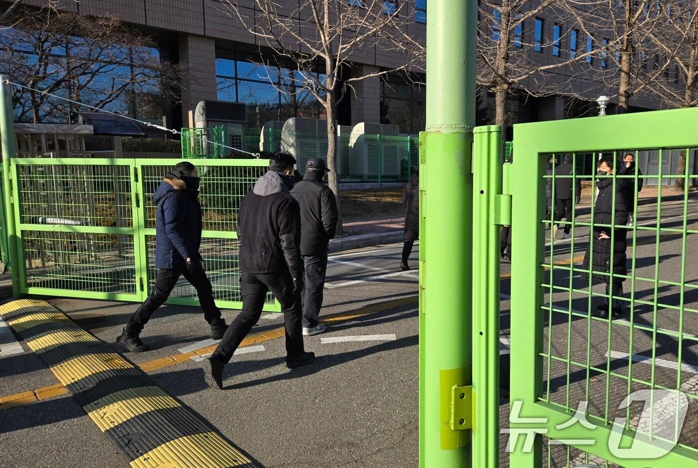 본문 이미지 - 윤석열 대통령 체포영장 집행이 진행되고 있는 15일 오전 경기도 정부과천청사 고위공직자범죄수사처에서 대통령 경호처 관계자들로 추정되는 인원들이 공수처 청사 진입로를 살펴보고 있다. (공동취재) 2025.1.15/뉴스1 ⓒ News1 김영운 기자