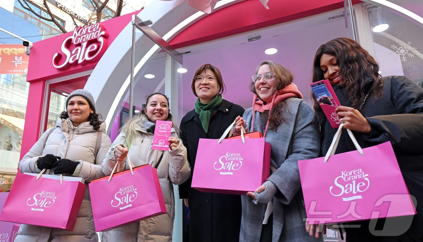 장미란 문화체육관광부 제2차관이 15일 서울 중구 국립극단 명동예술극장 앞에 마련된 코리아그랜드세일 웰컴센터 앞에서 외국인 관광객에게 선물을 전달한 뒤 기념촬영을 하고 있다.&#40;문체부 제공&#41;