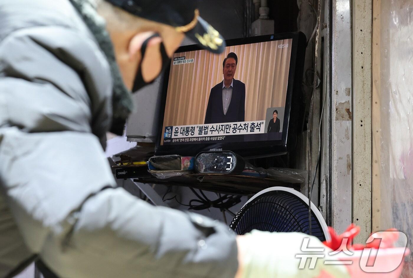 고위공직자범죄수사처와 경찰로 구성된 공조수사본부가 윤석열 대통령에 대한 2차 체포영장 집행한 15일 오후 서울 시내 전통시장에서 한 상인이 윤석열 대통령 체포 관련 뉴스를 시청하고 있다. 2025.1.15/뉴스1 ⓒ News1 임세영 기자
