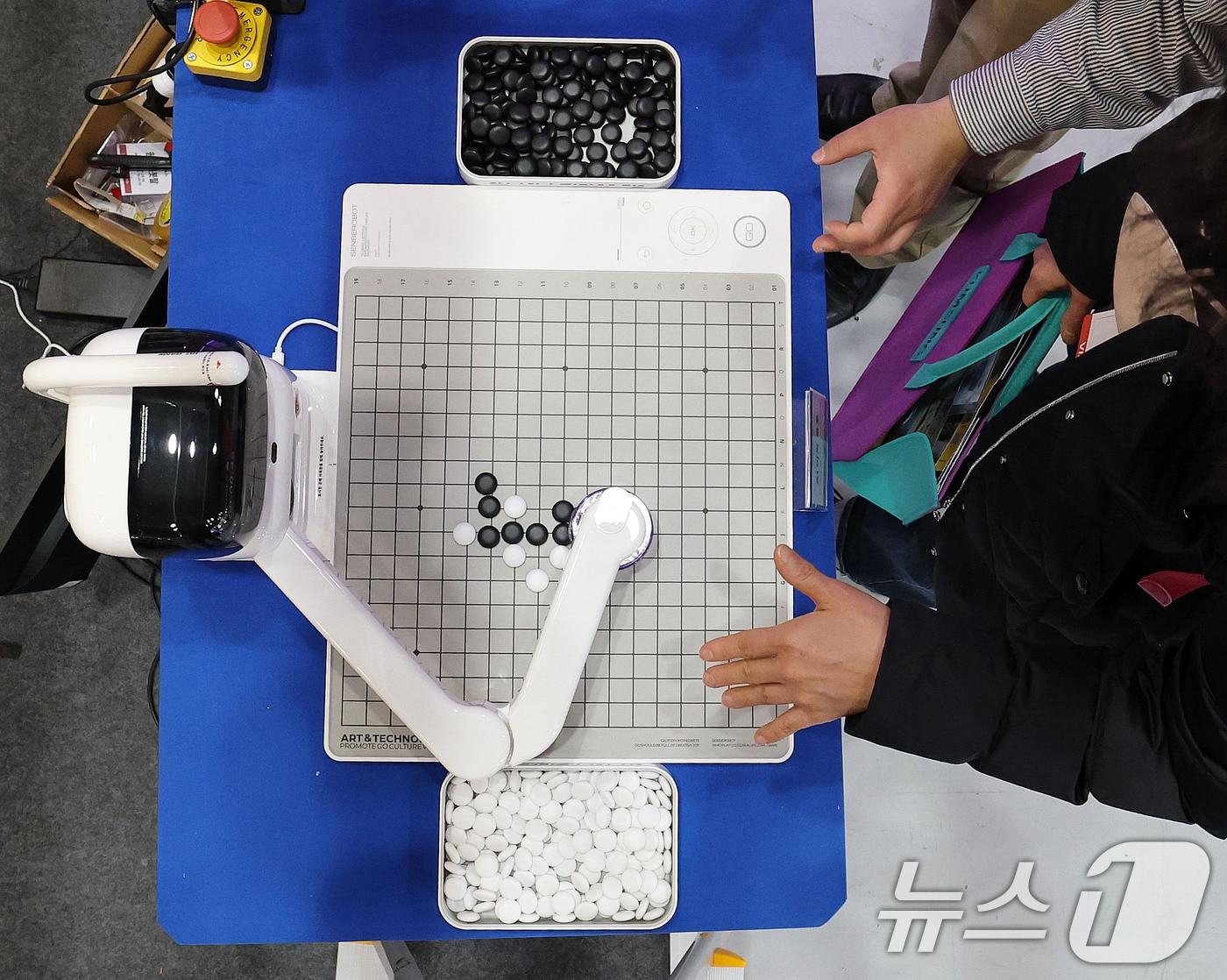 본문 이미지 - 15일 서울 강남구 코엑스에서 열린 대한민국 교육박람회에서 관람객이 유엔디 알파에듀의 AI 바둑 로봇과 오목을 두고 있다. 아시아 최대규모의 교육·에듀테크 전문 박람회인 이번 전시는 17일까지 계속된다. 2025.1.15/뉴스1 ⓒ News1 박세연 기자