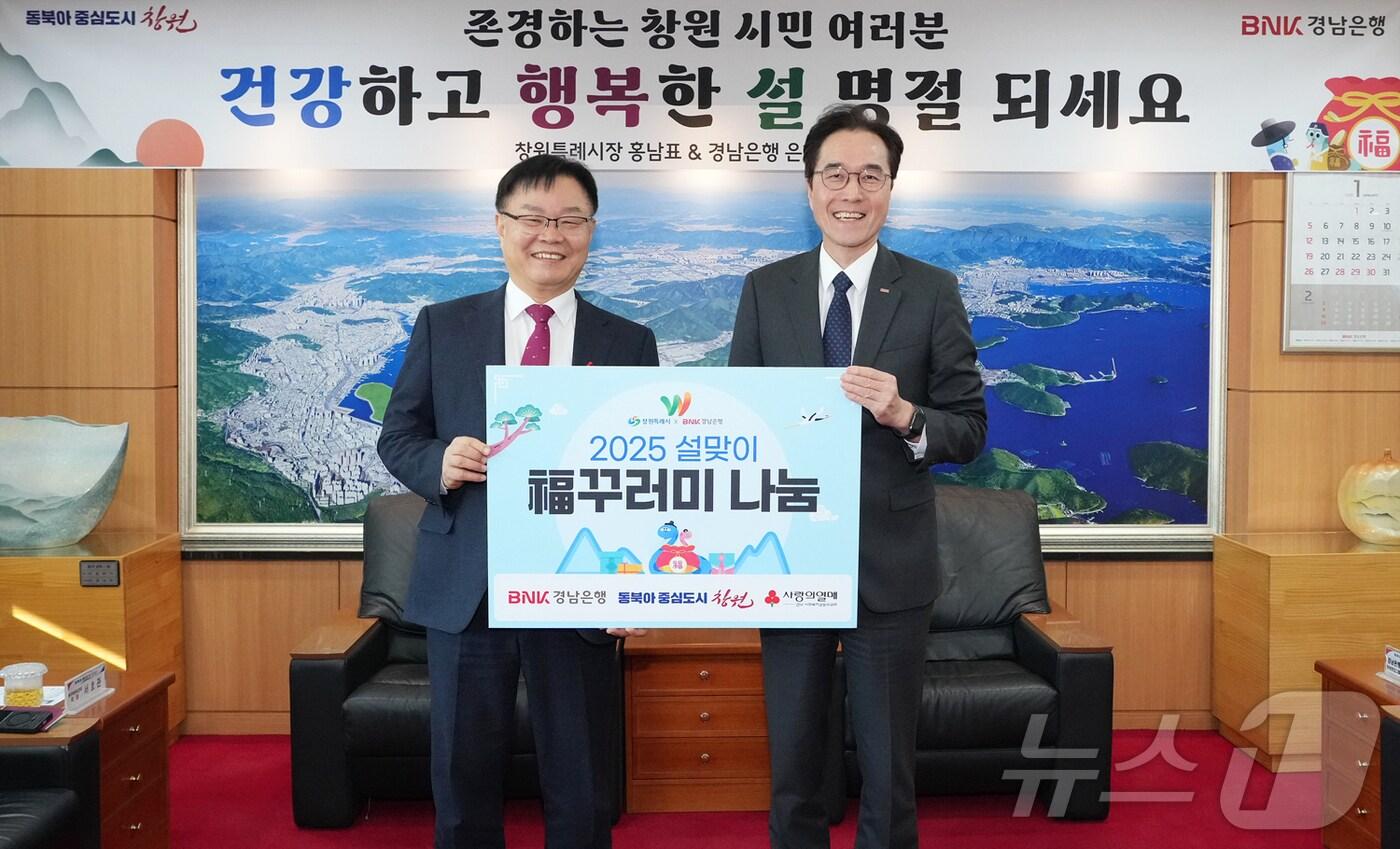 예경탁 BNK경남은행장(오른쪽)이 15일 창원시청에서 홍남표 시장에게 ‘복꾸러미 기탁 증서’를 전달하고 있다.(경남은행 제공)