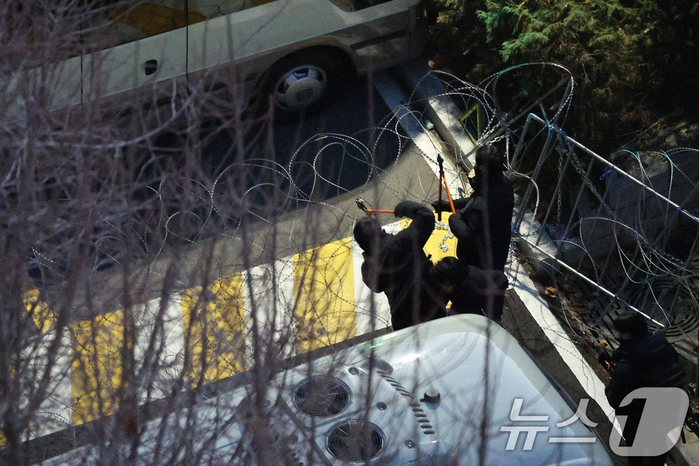 고위공직자범죄수사처(공수처)와 경찰로 구성된 공조수사본부가 윤석열 대통령에 대한 2차 체포영장 집행에 돌입한 15일 오전 공수처 수사관들과 경찰 인력이 서울 용산구 한남동 대통령 관저로 진입하며 철조망을 제거하고 있다. 2025.1.15/뉴스1 ⓒ News1 신웅수 기자