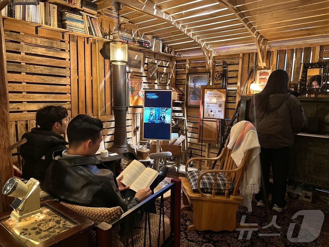 본문 이미지 - 고객들이 라이프집 팝업 스토어 '낭만 오두막.zip'에서 LG전자의 이동식 라이프 스타일 스크린 LG 스탠바이미 등 팝업스토어 내/외부에 설치된 LG전자 제품들과 이벤트를 체험하고 둘러보고 있는 모습(LG전자 제공). ⓒ 뉴스1