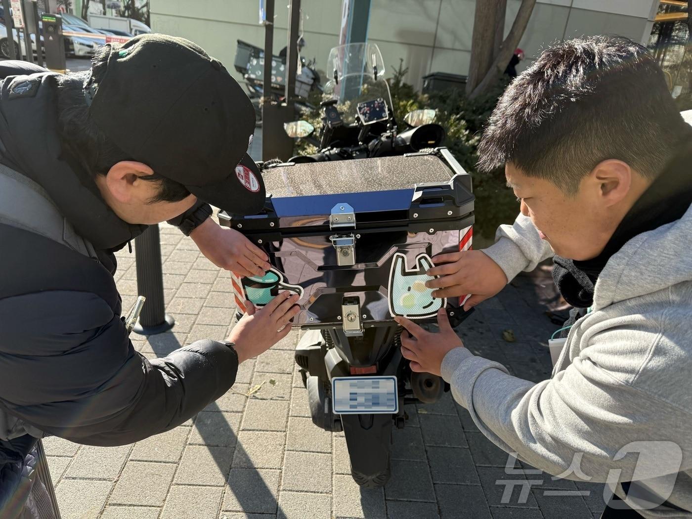 본문 이미지 - 우아한청년들이 이륜차 반사스티커 부착 캠페인을 진행하는 모습 (우아한청년들 제공)