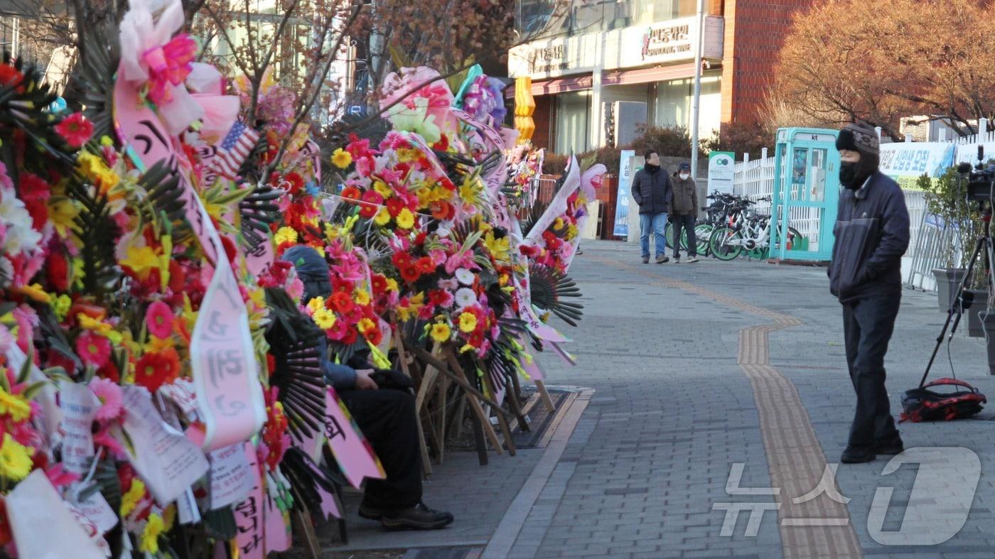 윤석열 대통령이 체포된 15일 오후, 한 남성이 서울 용산구 한남동에서 박종준 전 경호처장을 응원하는 화환을 응시하고 있다. 2025.1.15/뉴스1 ⓒ 뉴스1 김민재 기자