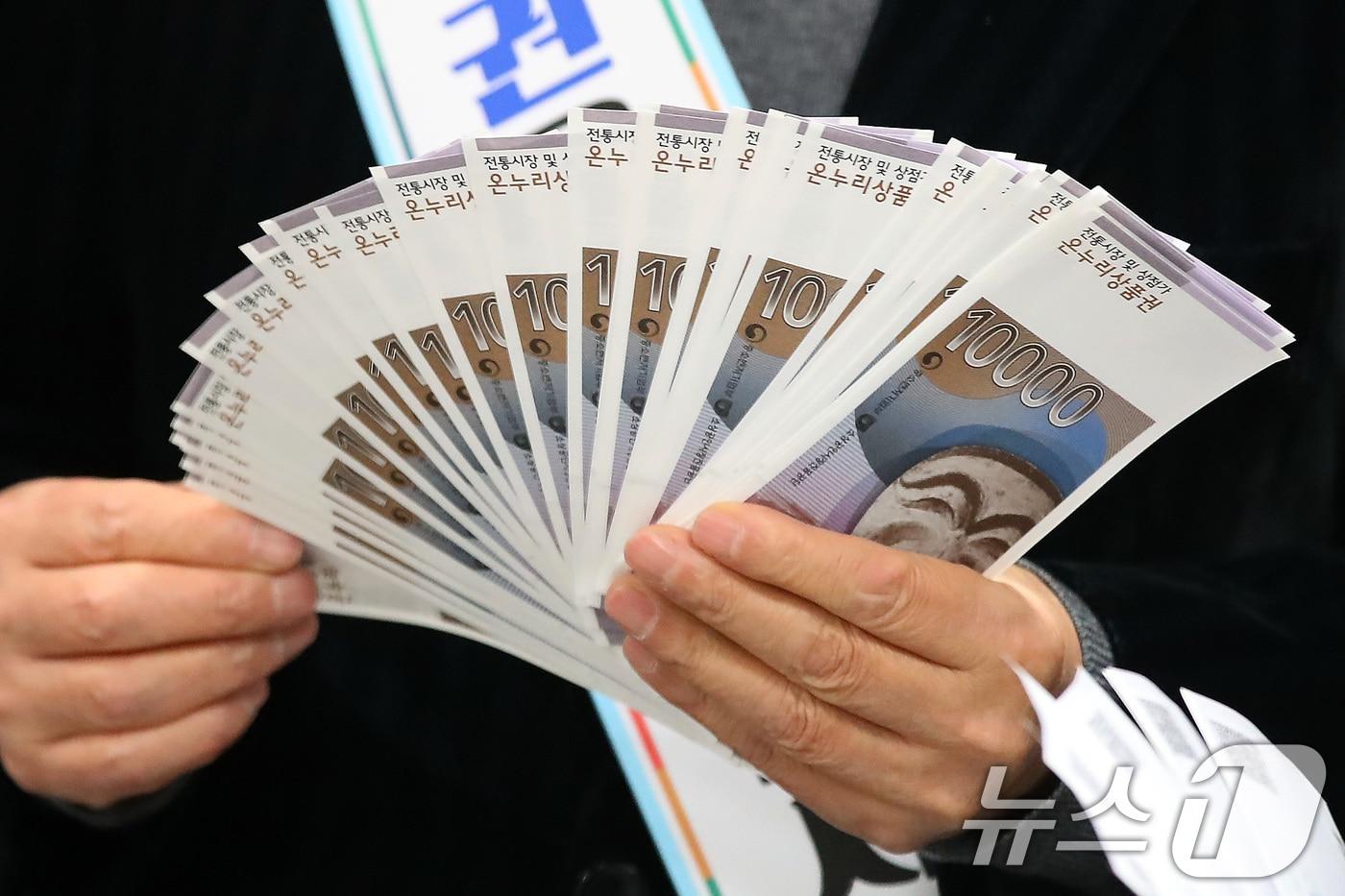 지난 1월 대구 중구 iM뱅크 중구청지점에서 열린 '설맞이 전통시장 온누리상품권 구매 촉진 행사' 참석자들이 전통시장 활성화를 위해 구매한 온누리상품권을 펼치고 있다. 2025.1.16/뉴스1 ⓒ News1 공정식 기자