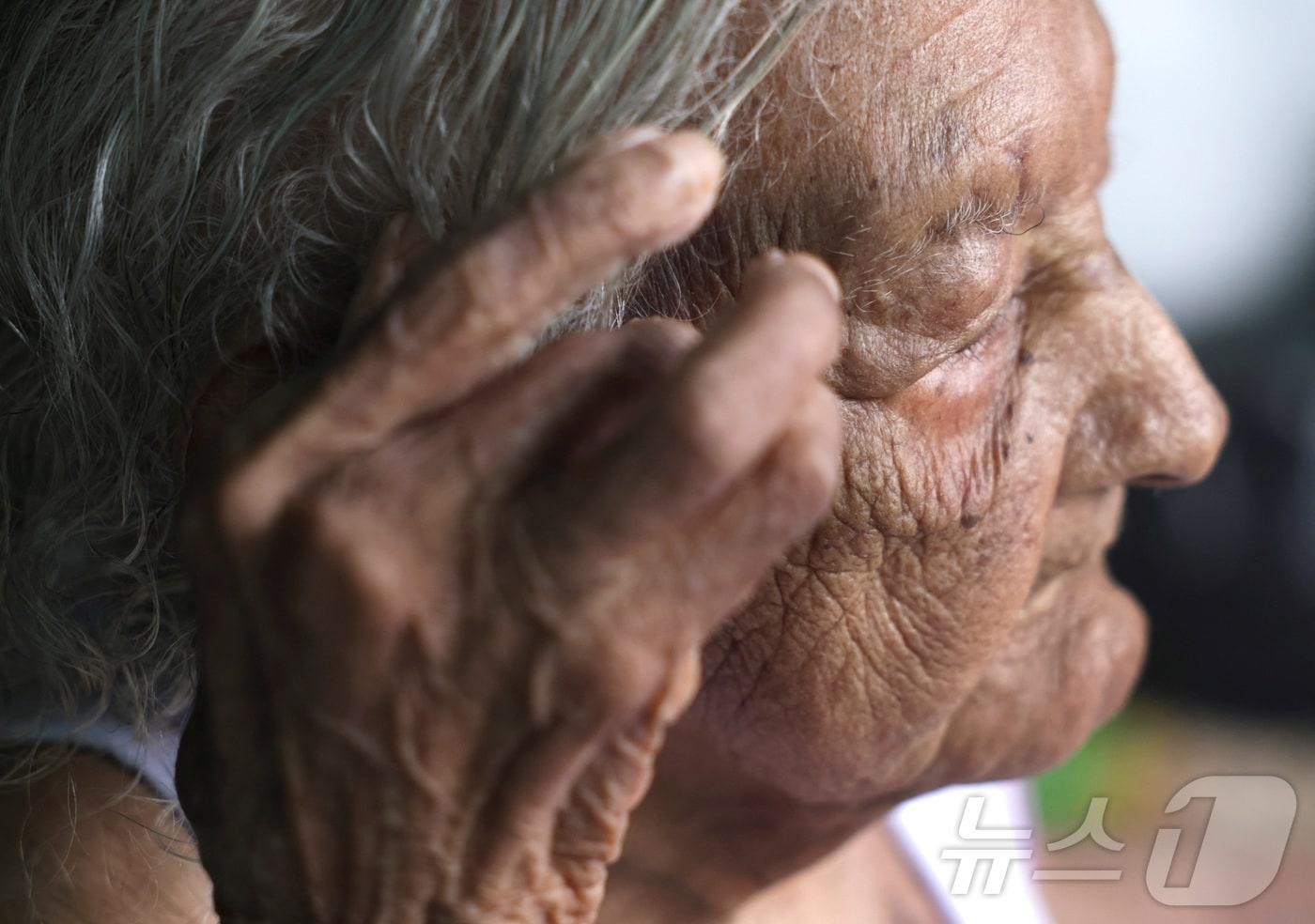 브라질 리우데자네이루 이타페루나의 자택에서 119세의 데올리라 글리세리아 페드로 다 시우바가 머리를 넘기고 있다. 2025.01.14/ ⓒ 로이터=뉴스1 ⓒ News1 권진영 기자