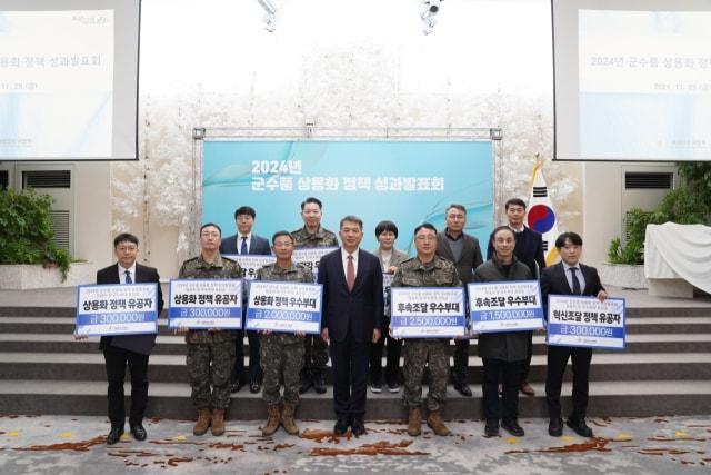 본문 이미지 - ‘2024년 군수품 상용화 정책 성과 발표회’ 당시 유공자들이 기념촬영을 하고 있다.(국방부 제공)