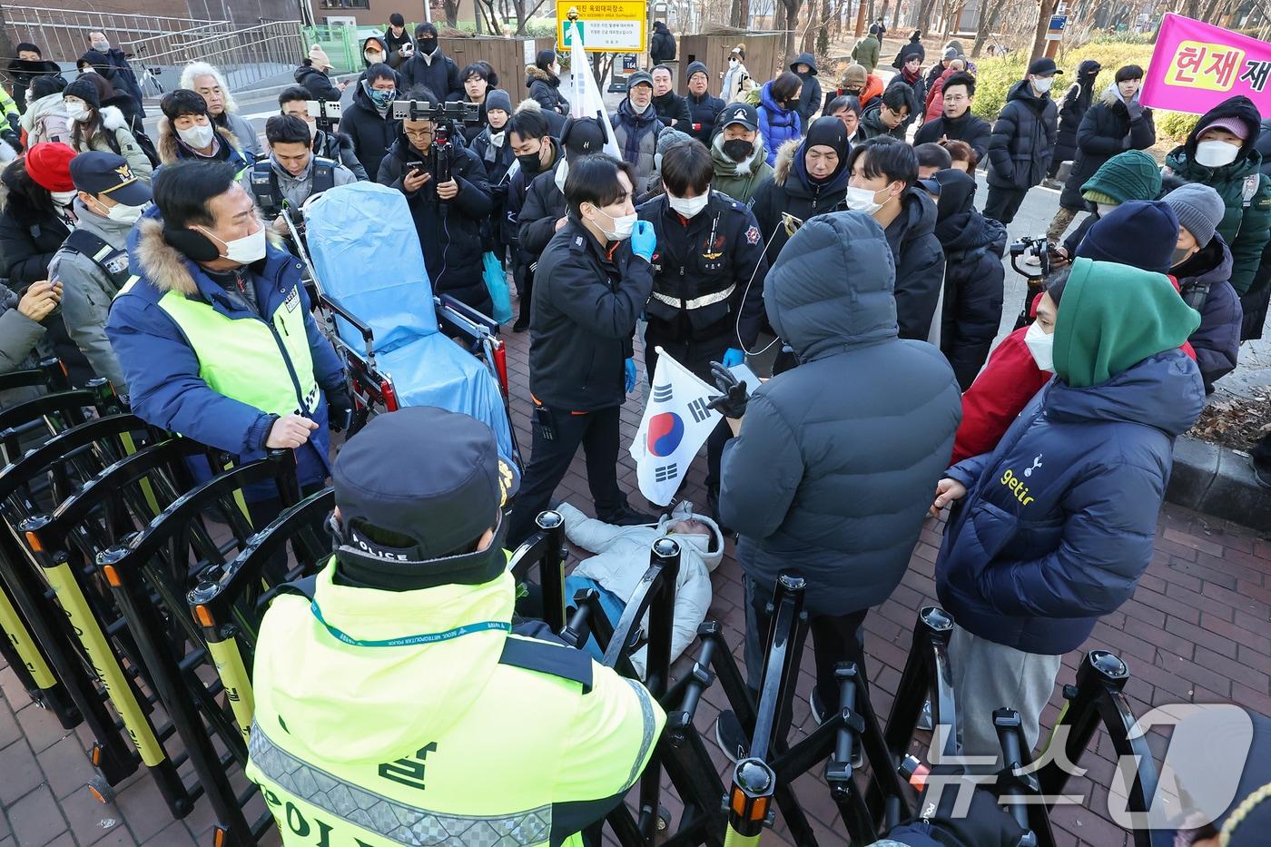 윤석열 대통령의 영장심사가 실시되는 18일 오전 서울 마포구 서울서부지방법원 앞에서 집회를 이어가던 윤 대통령의 지지자가 경찰의 강제해산 과정에서 실신해 구급대원이 출동해 있다. 2025.1.18/뉴스1 ⓒ News1 민경석 기자