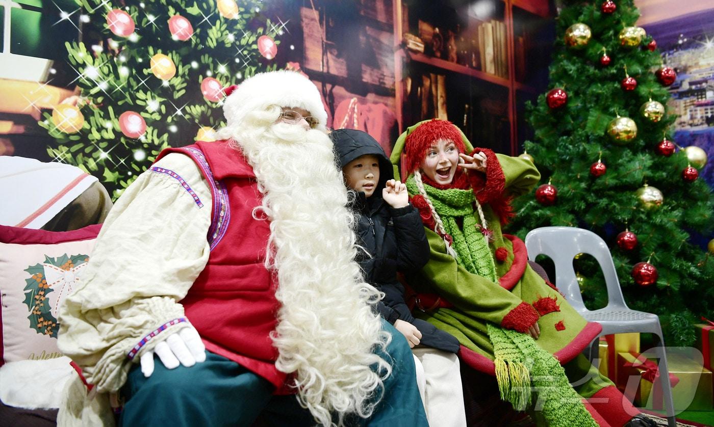 본문 이미지 - '산타의 고향' 핀란드 로바니에미시에서 날아온 '진짜 산타클로스'와 요정 '엘프'가 18일 강원 화천산천어축제장에 마련된 산타우체국을 방문해 관광객들과 기념촬영을 하고 있다.(화천군 제공) 2025.1.18/뉴스1 