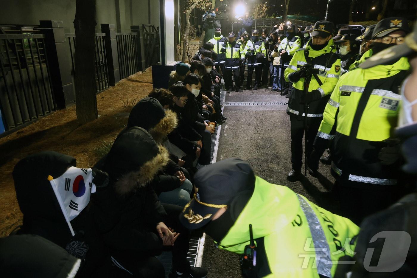 내란 우두머리 혐의로 체포된 윤석열 대통령의 영장실질심사가 열린 18일 오후 서울 마포구 서울서부지방법원에서 윤 대통령의 석방을 촉구하며 법원 담장을 넘어 들어온 청년들이 경찰에 붙잡혀 있다.(공동취재) 2025.1.18/뉴스1 ⓒ News1 민경석 기자