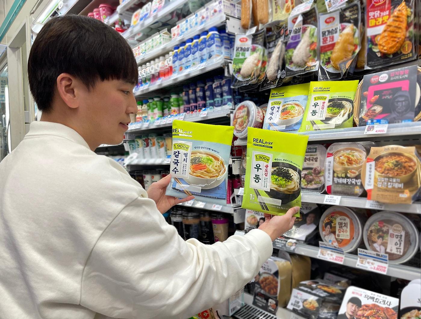 본문 이미지 - 모델이 GS25가 이번에 출시하는 완도김우동, 멸치칼국수 등 리얼프라이스 냉장면 2종을 들고 포즈를 취하고 있다(GS25 제공).