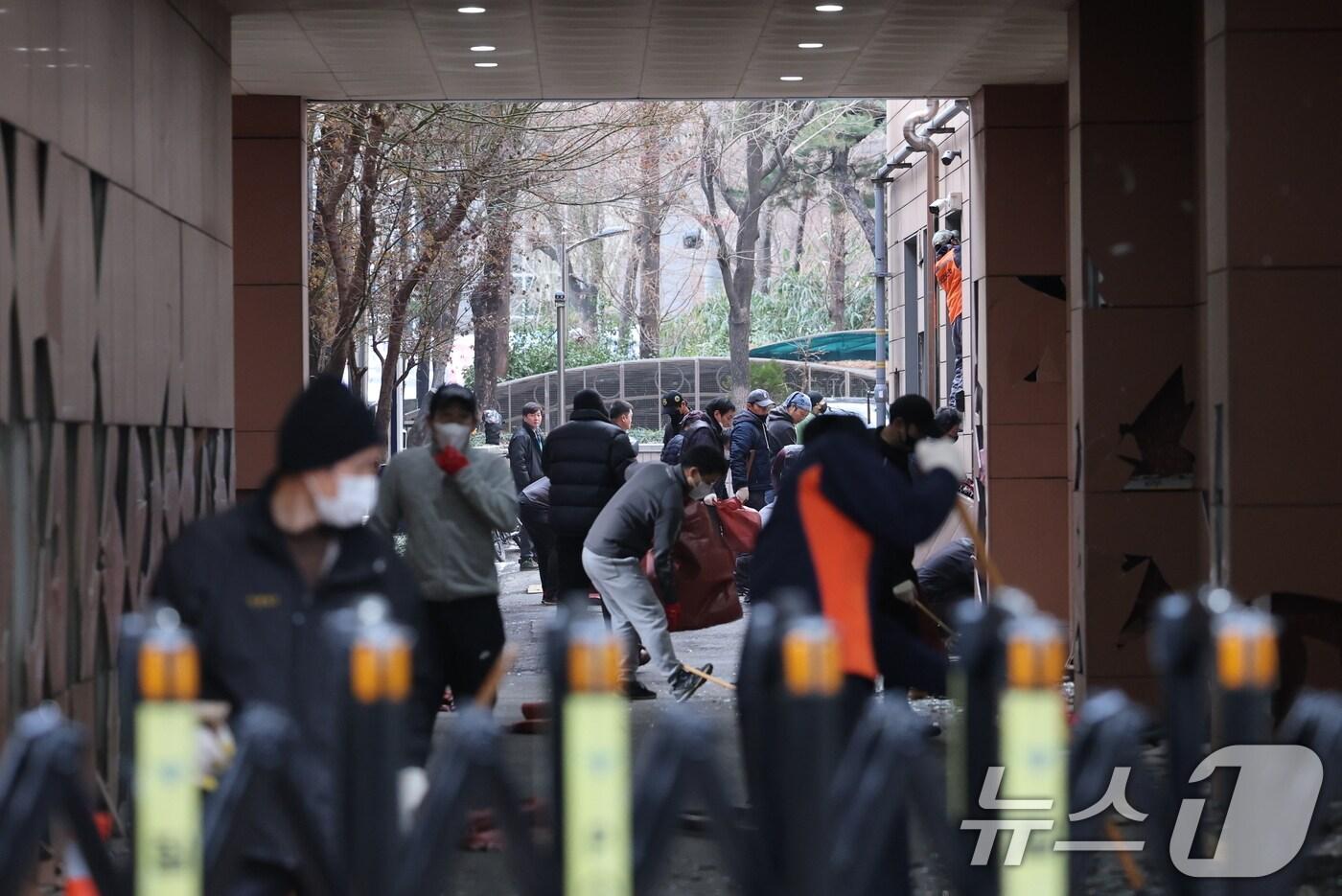 19일 오후 윤석열 대통령 지지자들의 폭력 난입 사태가 발생한 서울 마포구 서울서부지방법원에서 관계자들이 폐기물을 치우고 있다. 2025.1.19/뉴스1 ⓒ News1 오대일 기자