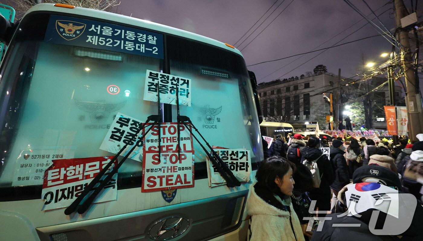 본문 이미지 - 윤석열 대통령 지지자들이 19일 오후 서울 종로구 헌법재판소 앞 경찰버스 차벽에 탄핵 반대 구호가 적힌 피켓들이 붙어 있다. 2025.1.19/뉴스1 ⓒ News1 박지혜 기자