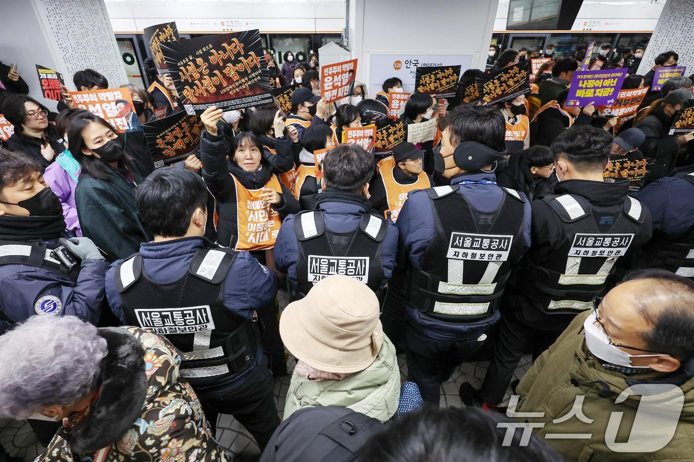 서울 종로구 3호선 안국역 승강장에서 새해 첫 출근길 지하철 탑승 시위에 나선 전국장애인차별철폐연대(전장연) 관계자들과 탑승 저지에 나선 서울교통공사 지하철 보안관들 뒤로 열차에서 하차한 시민들이 지나가고 있다. 2025.1.2/뉴스1 ⓒ News1 민경석 기자