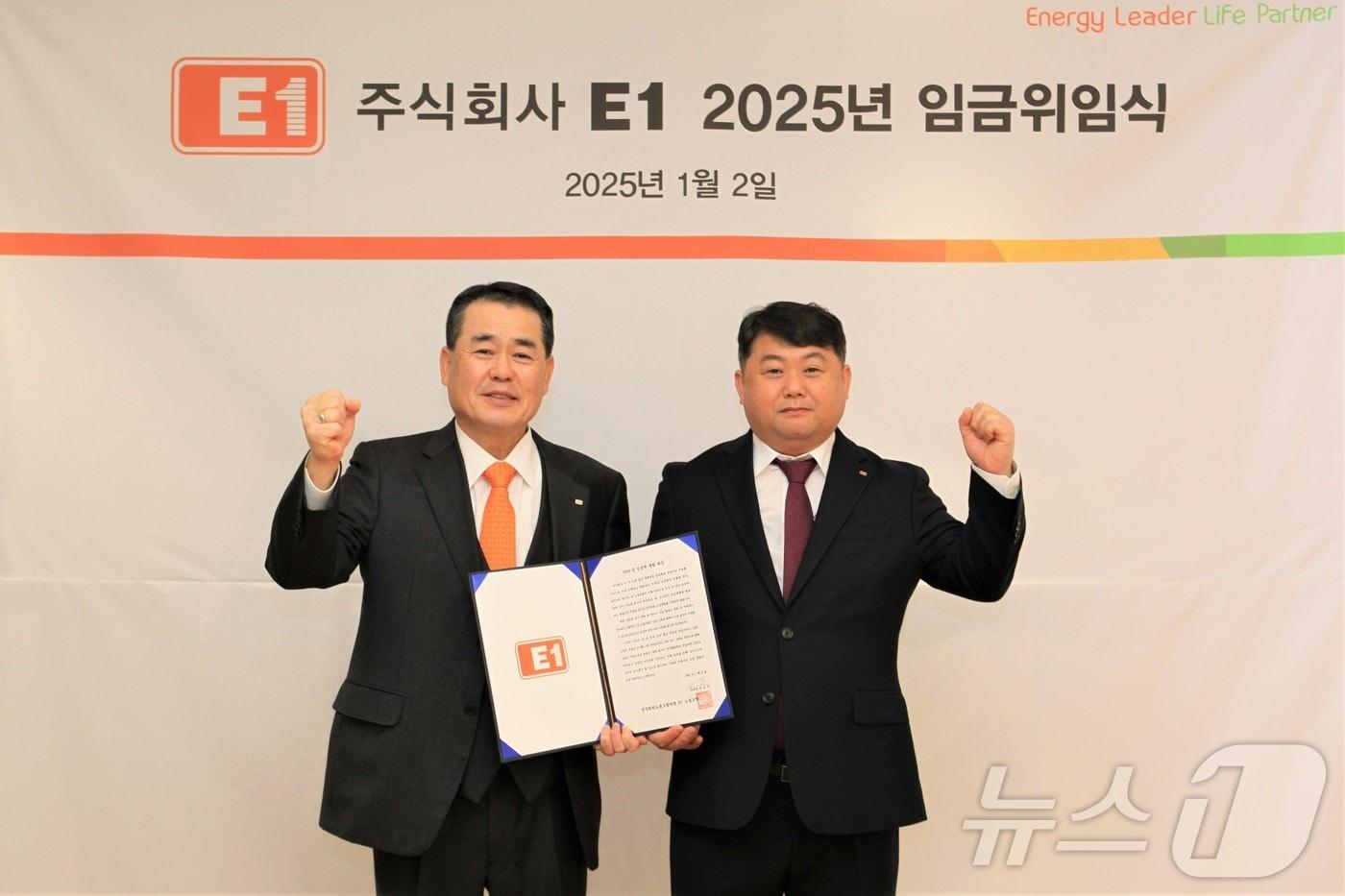 구자용 E1 회장(왼쪽)과 박승규 E1 노조위원장이 2일 서울 용산구 본사에서 2025년도 임금에 관한 위임장을 들고 기념 촬영을 하고 있다.(E1 제공)