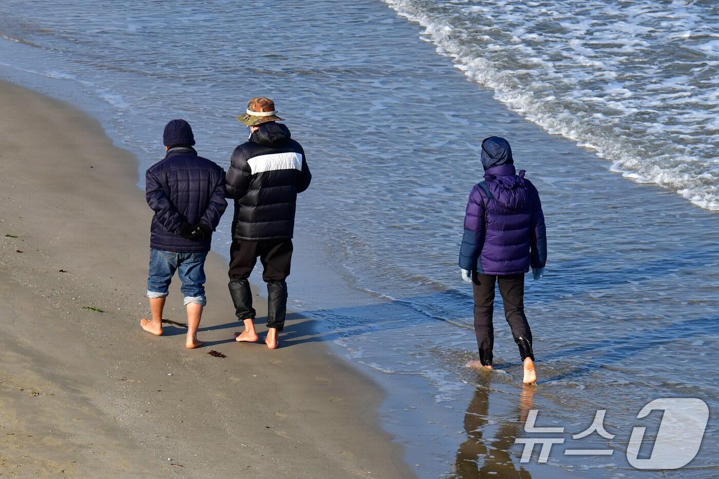 본문 이미지 - 2일 오후 경북 포항시 송도해수욕장에서 시민들이 맨발로 걸어가고 있다. 2025.1.2/뉴스1 ⓒ News1 최창호 기자