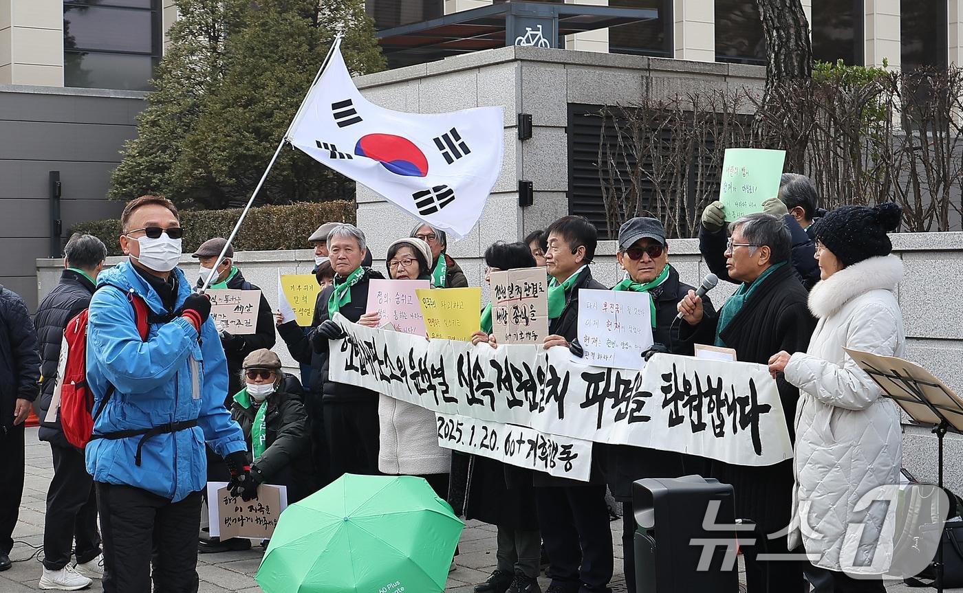 내란 우두머리 혐의로 구속된 윤석열 대통령의 탄핵 사건 3차 변론기일을 하루 앞둔 20일 오후 서울 종로구 헌법재판소 앞에서 한 윤 대통령 지지자가 태극기를 흔들며 전원일치 파면 촉구 기자회견 앞을 지나가고 있다. 한편, 윤 대통령 측은 구속 후 고위공직자범죄수사처&#40;공수처&#41;의 두 번째 부름에도 응하지 않기로 했지만 헌법재판소의 탄핵심판에는 곧 출석할 것이라고 밝혔다. 2025.1.20/뉴스1 ⓒ News1 김진환 기자