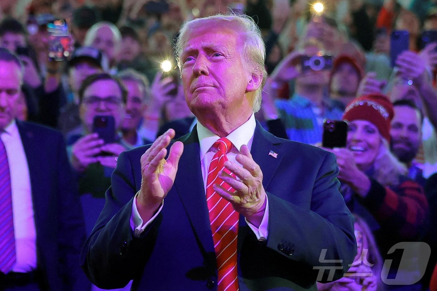 본문 이미지 - 도널드 트럼프 미국 대통령 당선인이 19일(현지시간) 취임 하루를 앞두고 워싱턴 '캐피털 원 아레나' 경기장에서 열린 MAGA 대선 승리 축하 집회에 도착하며 박수를 치고 있다. 2025.01.20 ⓒ 로이터=뉴스1 ⓒ News1 우동명 기자