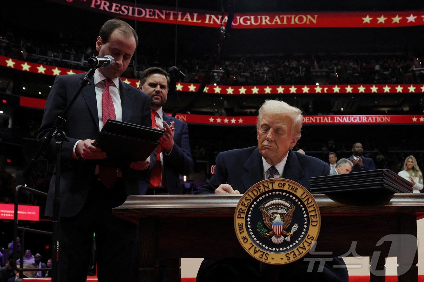 도널드 트럼프 미국 대통령이 20일&#40;현지시간&#41; 워싱턴 &#39;캐피털 원 아레나&#39;에서 열린 취임식 축하 집회에서 행정명령에 서명하고 있다. 2025.01.20 ⓒ 로이터=뉴스1 ⓒ News1 최종일 기자