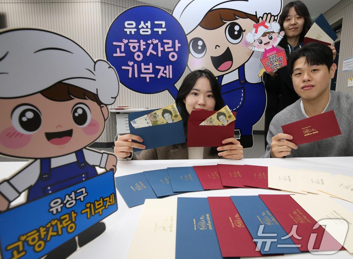 본문 이미지 - 22일 대전 유성구청 직원들이 구에서 제작한 고향사랑기부제를 홍보할 수 있는 세뱃돈 봉투를 선보이고 있다. 2025.1.22 ⓒ 뉴스1 김기태 기자