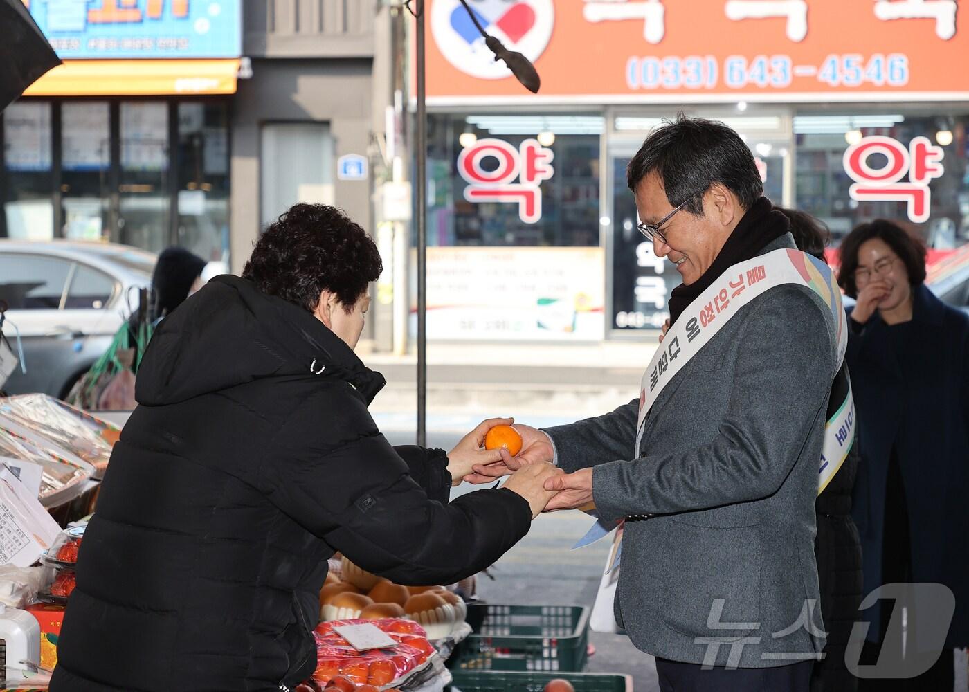 본문 이미지 - 김홍규 강원 강릉시장(사진 오른쪽)이 설 명절을 앞둔 22일 지역 대표 전통시장인 중앙·성남시장에서 제수용품을 구매하고 있다.(강릉시 제공) 2025.1.22/뉴스1 