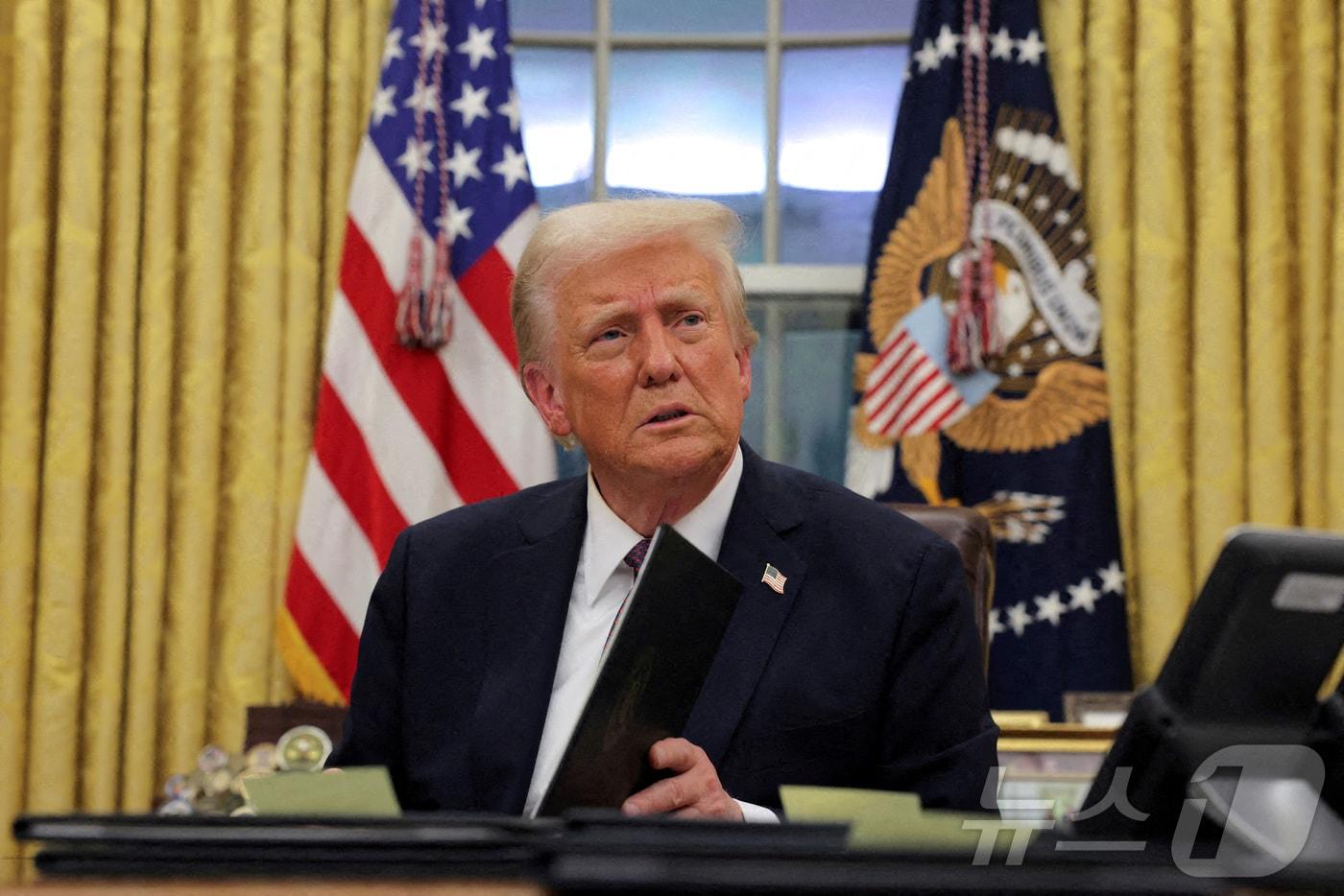 지난 20일&#40;현지시간&#41; 취임한 도널드 트럼프 미국 대통령이 워싱턴 백악관 집무실에서 2021년 1월 6일 의사당 폭동 사건 피고인들에 대한 행정명령과 사면을 발표하면서 문서에 서명하고 있다. ⓒ 로이터=뉴스1 ⓒ News1 류정민 특파원