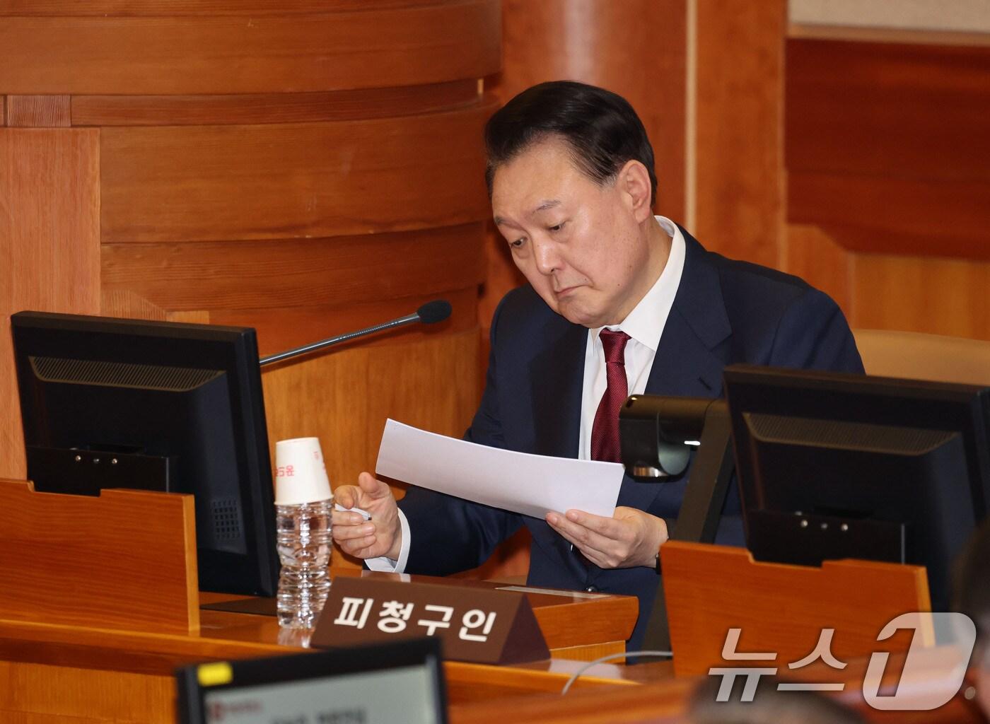 본문 이미지 - 윤석열 대통령이 23일 오후 서울 종로구 헌법재판소 대심판정에서 열린 탄핵심판 4차 변론기일에 출석해 메모지를 살펴보고 있다. 2025.1.23/뉴스1 ⓒ News1 사진공동취재단