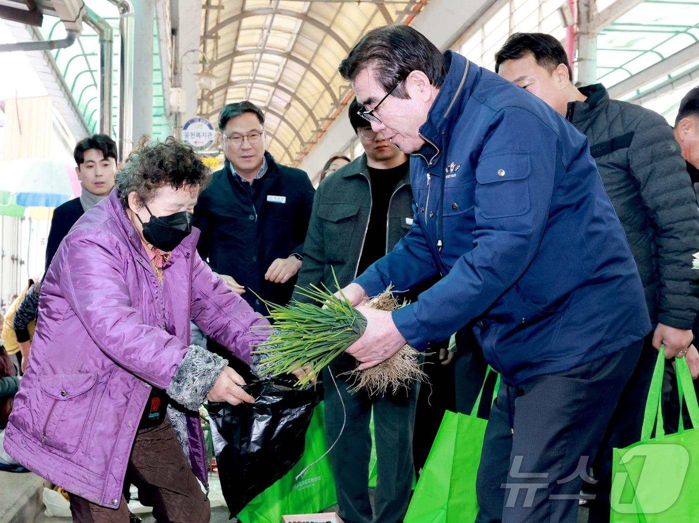 본문 이미지 - 김동일 보령시장이 전통시장에서 잘을 보고 있다.(보령시 제공)/뉴스1