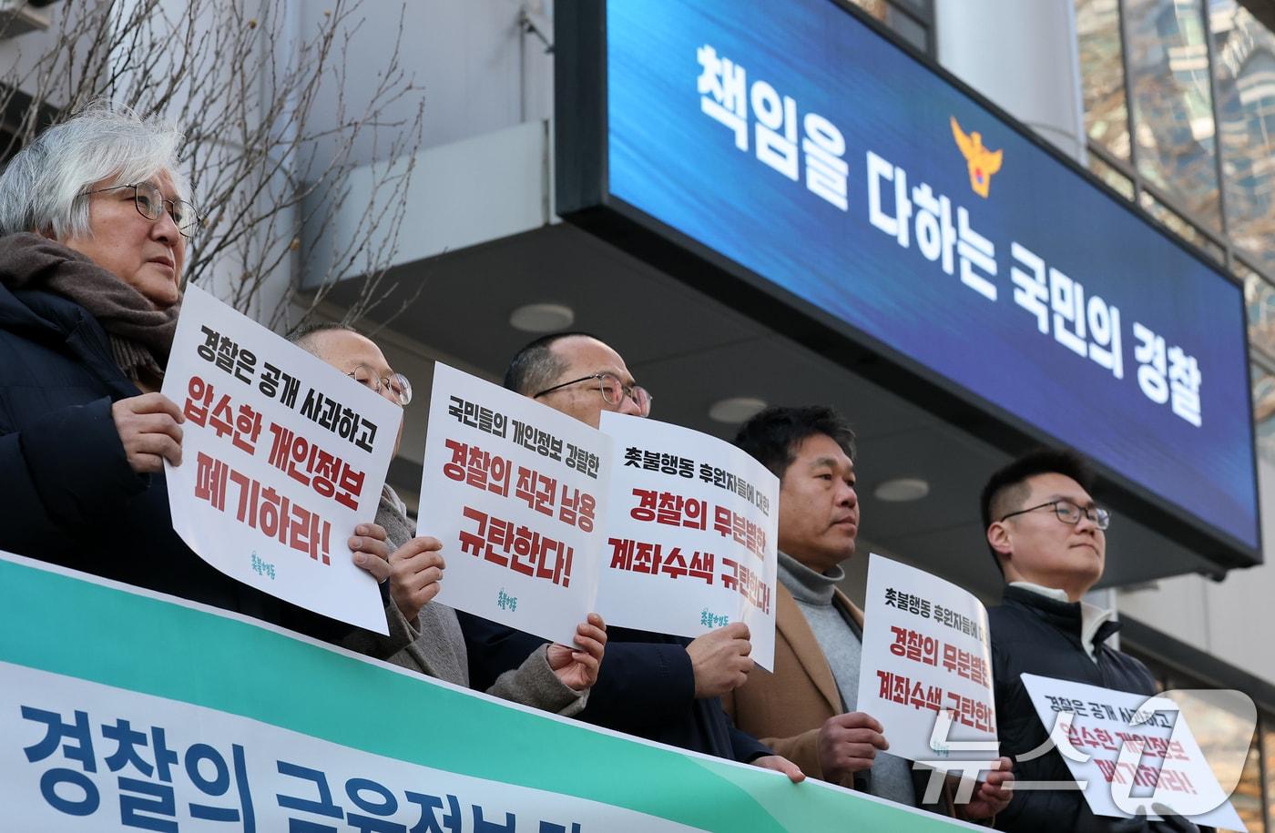 촛불행동 회원들이 서울 서대문구 경찰청 국가수사본부 앞에서 열린 촛불행동 회원, 후원인에 대한 경찰의 금융정보 강제수사 고발 기자회견에서 과도한 법 집행을 규탄하는 피켓을 들고 있다. 2025.1.24/뉴스1 ⓒ News1 오대일 기자