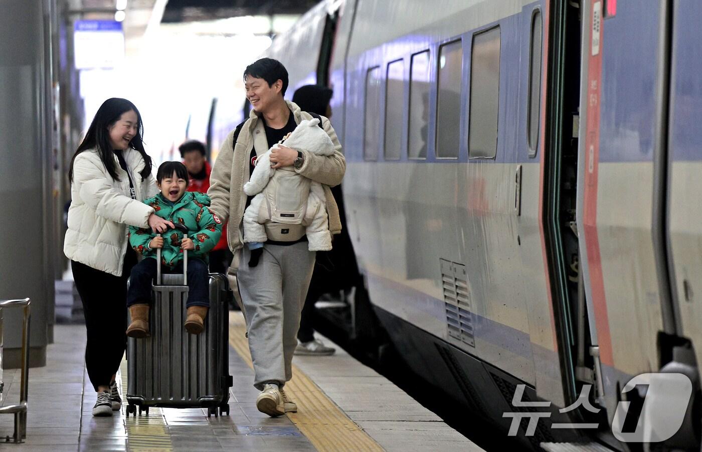 본문 이미지 - 설 연휴를 하루 앞둔 24일 서울 용산구 서울역에서 귀성길을 떠나는 가족이 기차로 향하고 있다. 2025.1.24/뉴스1 ⓒ News1 장수영 기자