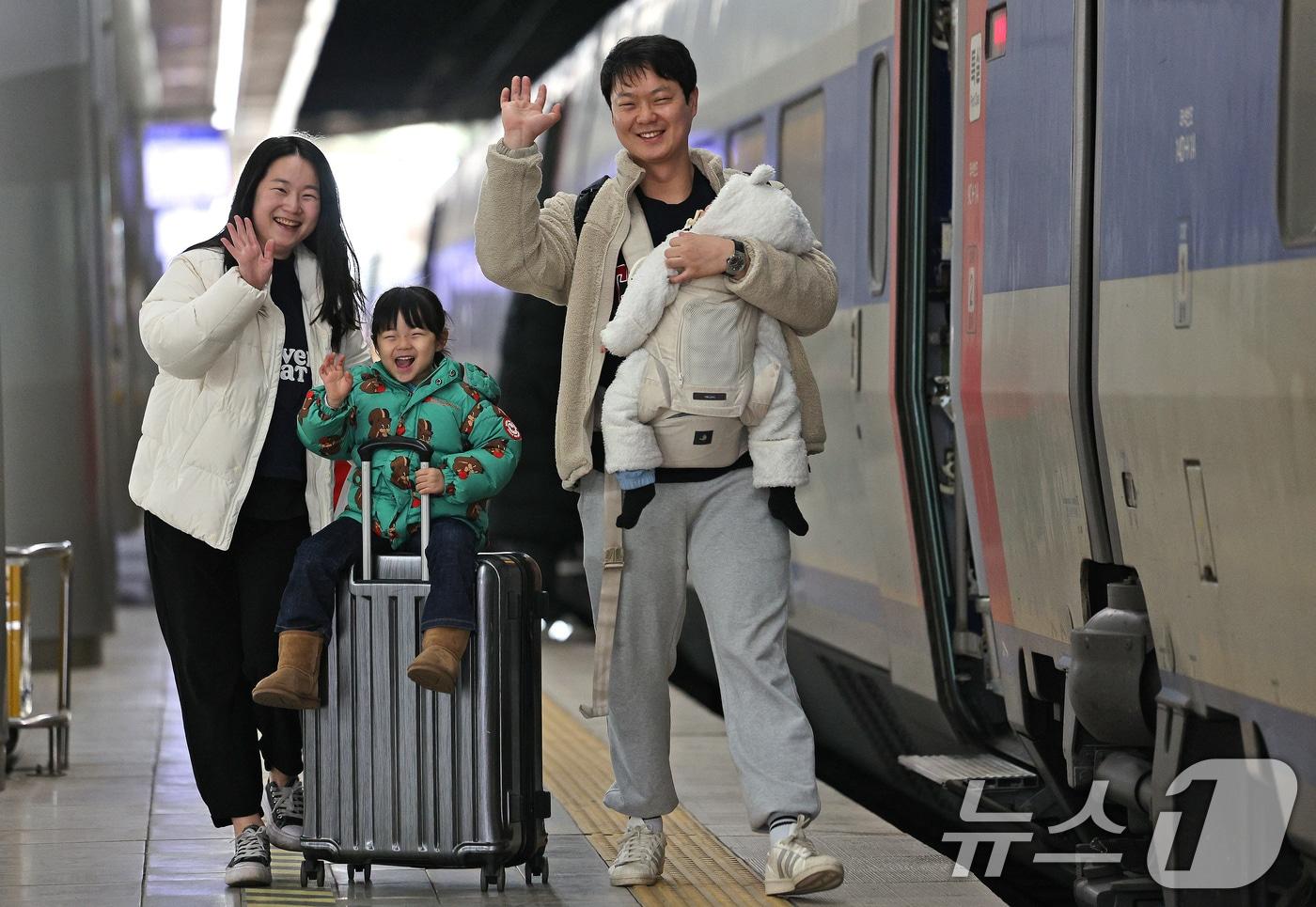 설 연휴를 하루 앞둔 24일 오전 서울 용산구 서울역에서 귀성길을 떠나는 가족이 손인사를 하고 있다. 2025.1.24/뉴스1 ⓒ News1 장수영 기자