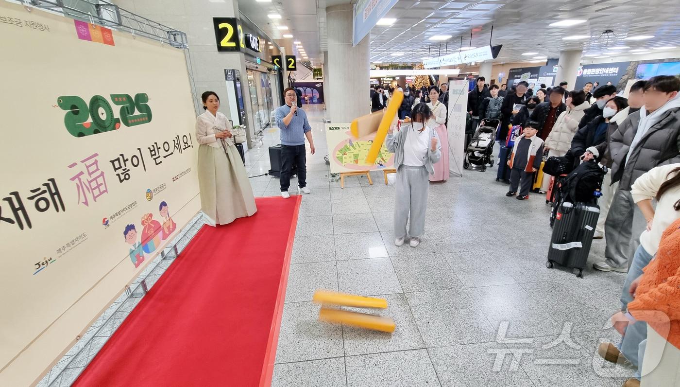 설 연휴를 하루 앞둔 24일 오후 제주국제공항 1층 국내선 도착장 앞에서 설 맞이 윷놀이 이벤트가 진행되고 있다.2025.1.24./뉴스1