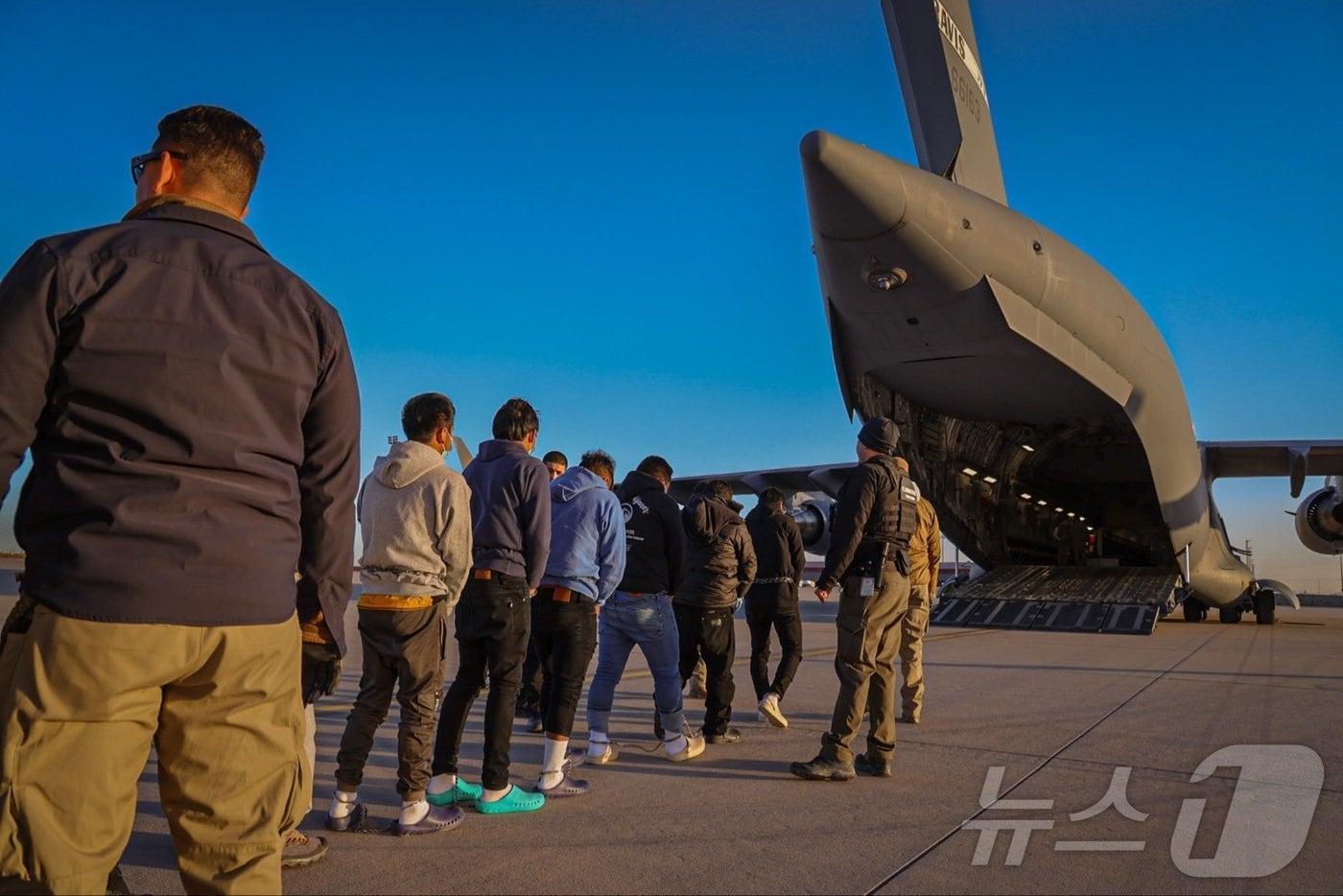 미국 남부 지역 한 군부대 비행장에서 수갑을 찬 이주민들이 군용기에 탑승하고 있다. 캐롤라인 레빗 백악관 대변인이 24일(현지시간) 엑스 계정에 게재한 사진이다.(출처 : 캐롤라인 레빗 백악관 대변인 엑스 계정) ⓒ News1 류정민 특파원