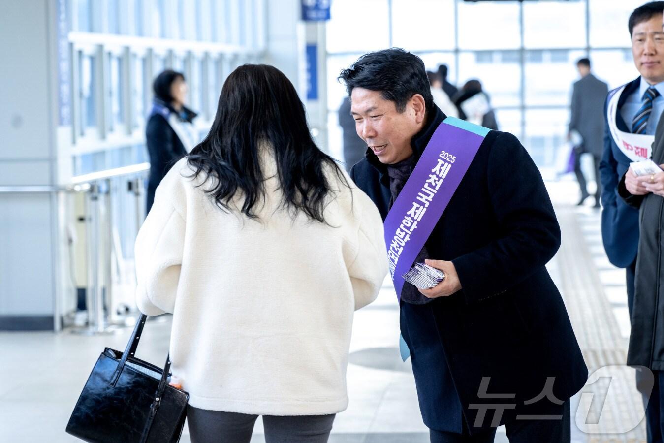 본문 이미지 - 김창규 제천시장이 귀성객들에게 시의 &#39;3대 국제행사&#39;를 적극 홍보하고 있다.&lt;제천시 제공&gt;/뉴스1 