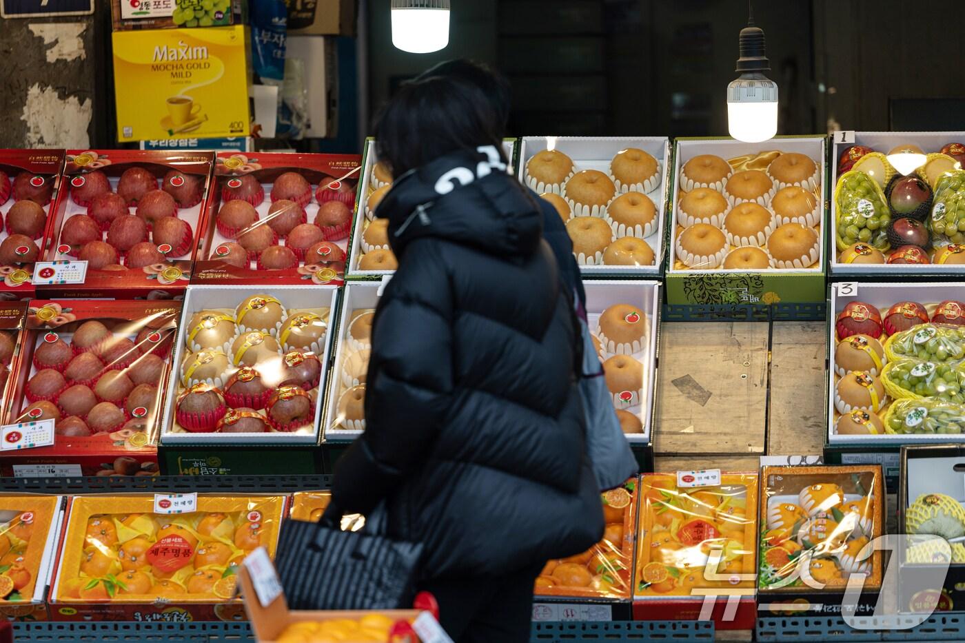 서울 동대문구 청량리종합시장을 찾은 시민이 사과와 배 등을 둘러보고 있다. 2025.1.26/뉴스1 ⓒ News1 이승배 기자