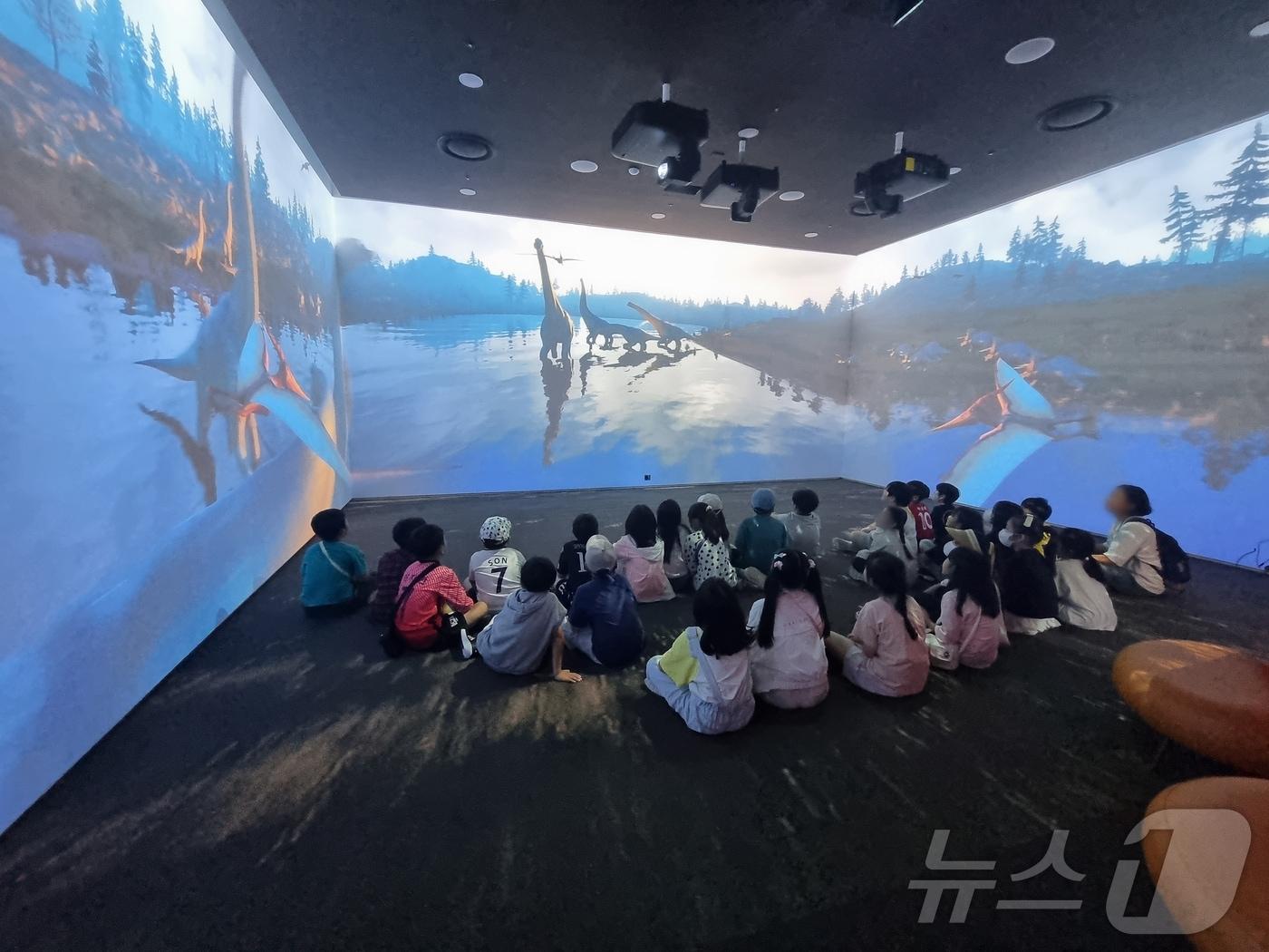 본문 이미지 - 어린이들이 달성화석박물관에서 영상을 보고 있다.&#40;대구 달성군 제공&#41;