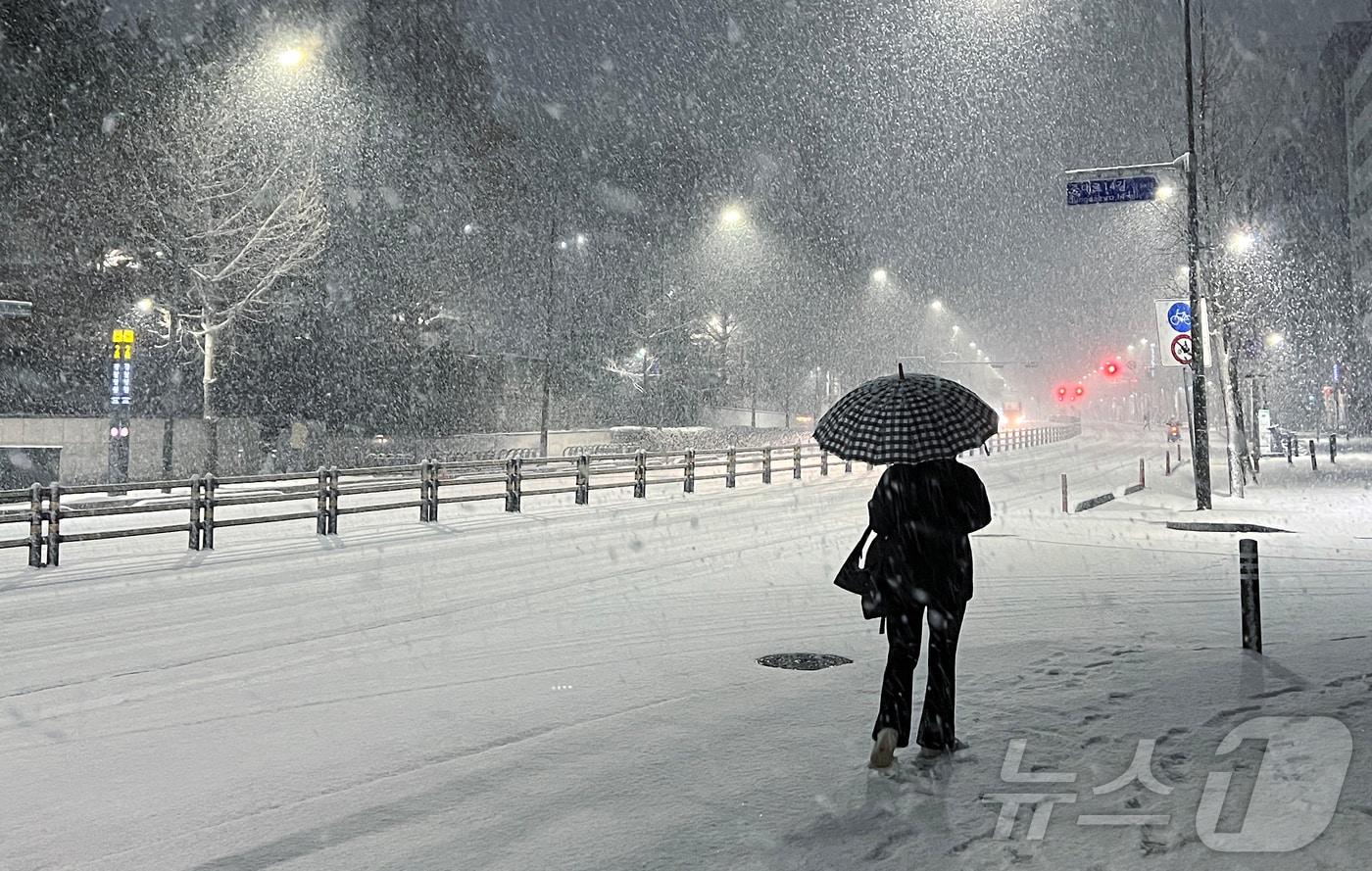 본문 이미지 - 대구 군위와 경북 구미에 대설주의보를 발효했다. 설 명절 연휴 사흘째이자 대설특보가 발효된 지난 27일 밤 서울 송파구 거리에서 시민이 쏟아지는 눈발을 헤치며 발걸음을 재촉하고 있다. 2025.1.27/뉴스1 ⓒ News1 박정호 기자
